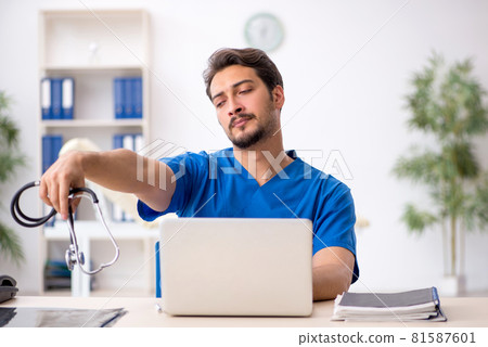 Tired young male doctor working in the clinic 81587601