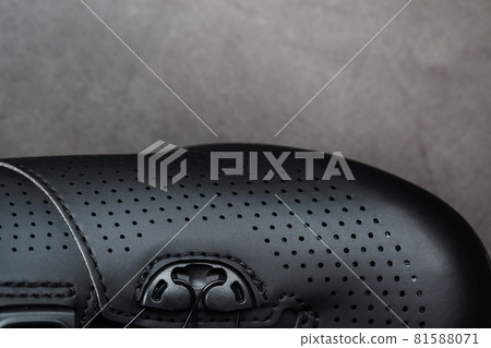 Sports shoes made of black perforated leather in a dark key. 81588071