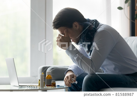 Sick frustrated businessman with flu, cold using laptop for work Sick frustrated businessman with flu, cold using laptop for work 81588987