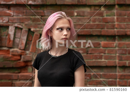 portrait of a teenage girl with pink hair on a brick wall background portrait of a teenage girl with pink hair on a brick wall background 81590160