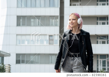 teen girl listening to music walking around the city 81590161