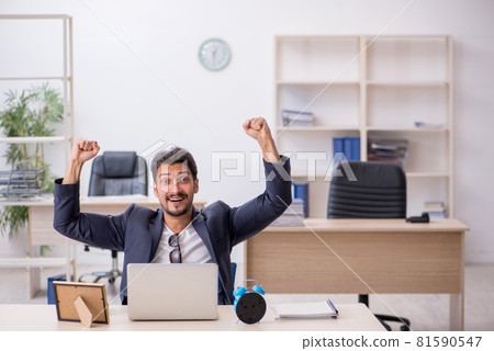Young handsome employee in time management concept 81590547