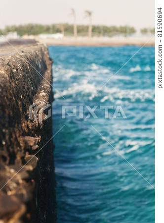 the waves strike the stone pier in blurring the waves strike the stone pier in blurring 81590694