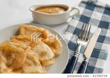 pancakes crepes with caramel sauce lay on a plate 81590734