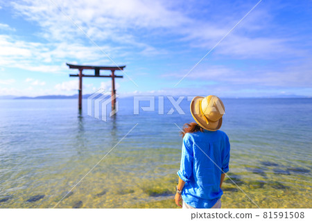 Female traveler looking at the lake and torii Female traveler looking at the lake and torii 81591508