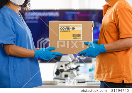 Asian man handling a box of Covid 19 vaccine to Asian nurse in hospital. Concept for Covid 19 vaccination. 81594740