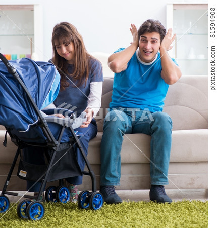 Young parents with their newborn baby in baby pram sitting on th Young parents with their newborn baby in baby pram sitting on th 81594908