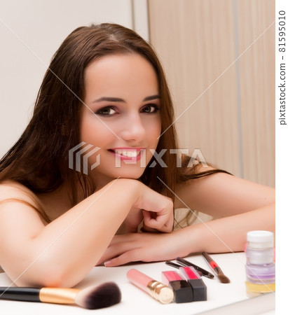 Woman doing make-up at home preparing for party Woman doing make-up at home preparing for party 81595010