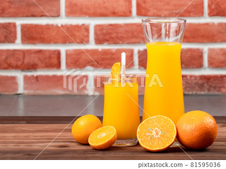 Fresh orange juice in jar and glass decorating with fresh orange on white wooden table. Studio picture concept for healthy diet Fresh orange juice in jar and glass decorating with fresh orange on white wooden table. Studio picture concept for healthy diet 81595036