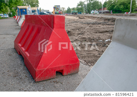 Plastic barriers on the construction site. Water and sewerage reconstruction and road construction 81596421