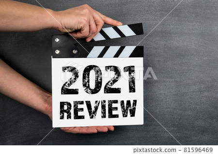 2021 Review concept. White movie clapper on a background of a dark chalk board 81596469