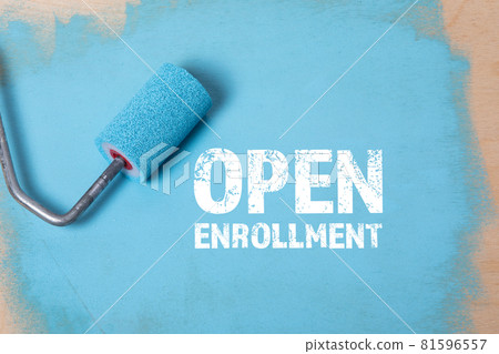 Open Enrollment. Paint roller with blue paint on a wooden surface Open Enrollment. Paint roller with blue paint on a wooden surface 81596557