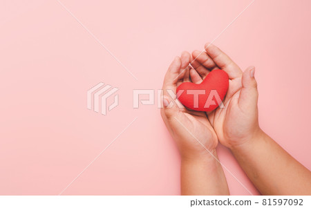 Little boy hand holding red heart on pink background, health care, love, organ donation, family insurance,CSR,world heart day, world health day, praying concept, Top view. 81597092