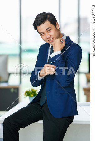 Stylish male entrepreneur standing in office 81597443