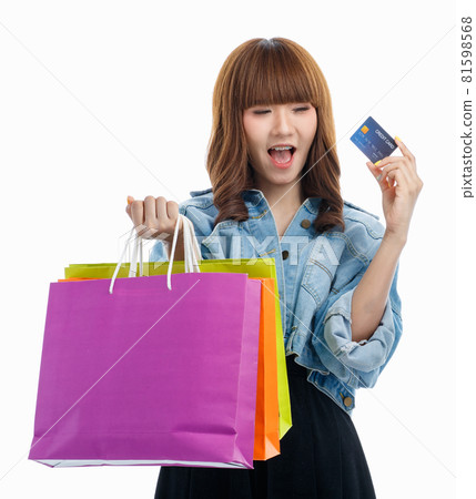 Woman holds credit card and shopping bags. 81598568