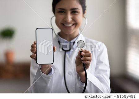 Close up young indian female cardiologist holding cellphone and stethoscope. 81599491