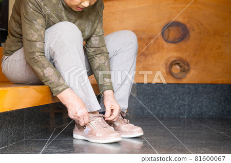 在前門穿運動鞋的老年婦女 在前門穿運動鞋的老年婦女 81600067