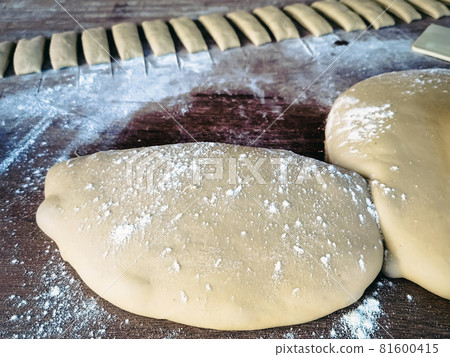 Wheat flour for making dough sticks or fried patongo on wooden board. Picture of one of the steps in making Patongo snacks. Patongo is a deep-fried dough stick. Popular breakfast for Thai people. Wheat flour for making dough sticks or fried patongo on wooden board. Picture of one of the steps in making Patongo snacks. Patongo is a deep-fried dough stick. Popular breakfast for Thai people. 81600415