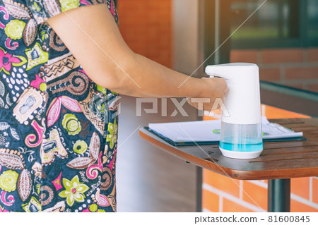 Automatic alcohol dispenser for cleaning hand to prevent the spreading of Coronavirus (Covid-19) on table before entrance to cafeteria. Healthcare concept. New normal lifestyle. Selective focus 81600845