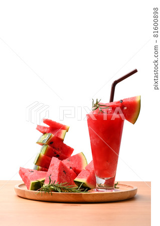 Glass of watermelon smoothie and sliced fresh watermelon on wooden table. Glass of watermelon smoothie and sliced fresh watermelon on wooden table. 81600898