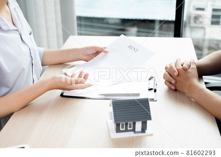 A real estate agent with a home model is talking to clients about renting a home and buying home insurance. Home rental and insurance concept A real estate agent with a home model is talking to clients about renting a home and buying home insurance. Home rental and insurance concept 81602293
