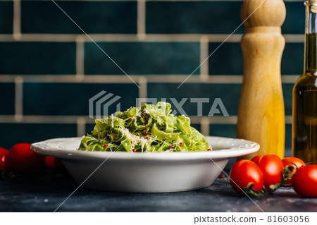 Italian pasta food background. Vegan italian pasta with spinach - Spinach Fettuccine Alfredo Pasta on a white plate. Old kitchen background. Copy space 81603056