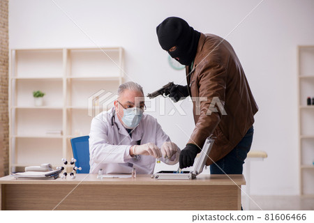 Masked man burglar stealing vaccine from old doctor 81606466