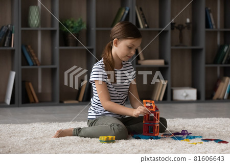 Joyful small preteen kid girl playing toys at home. 81606643