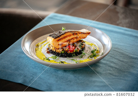 Salmon with creamy basil sauce and black rice 81607032
