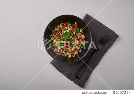 Traditional salad tabbouleh made of bulgur or couscous, poultry meat, parsley. mint, top view Traditional salad tabbouleh made of bulgur or couscous, poultry meat, parsley. mint, top view 81607254