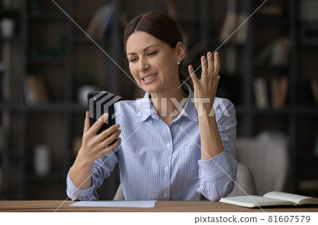 Displeased woman looking at phone screen, reading bad news 81607579