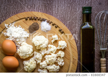 Healthy eating, vegetarian food. Raw cauliflower prepared for frying in a frying pan with spices in olive oil Healthy eating, vegetarian food. Raw cauliflower prepared for frying in a frying pan with spices in olive oil 81608347
