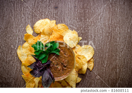 Potato chips with dipping sauce on a wooden table. Unhealthy food on a wooden background. 81608511
