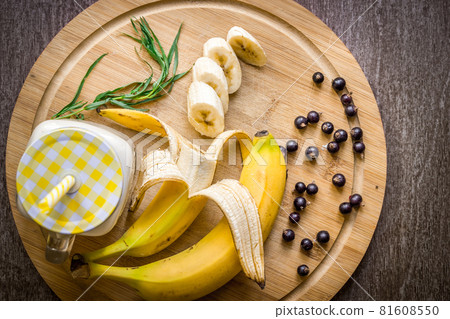 Banana smoothie and fresh banana on wooden table. 81608550