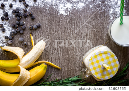 Banana smoothie and fresh banana on wooden table. Banana smoothie and fresh banana on wooden table. 81608565