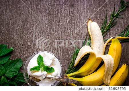 Ice cream with fresh banana and mint on wooden table. 81608793