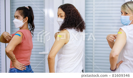 Three Asian female patients standing waiting in orderly straight line showing colorful plasters on shoulder after receiving Coronavirus Covid-19 vaccine injection shot in hospital already Three Asian female patients standing waiting in orderly straight line showing colorful plasters on shoulder after receiving Coronavirus Covid-19 vaccine injection shot in hospital already 81609346