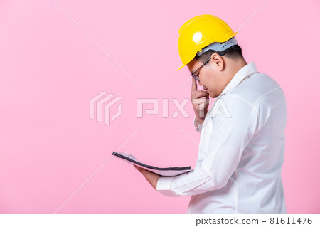 Industry worker or engineer working an architect builder studying layout plan serious civil engineer working with reading on blueprint isolated on pink blank copy space studio background,indoor studio 81611476
