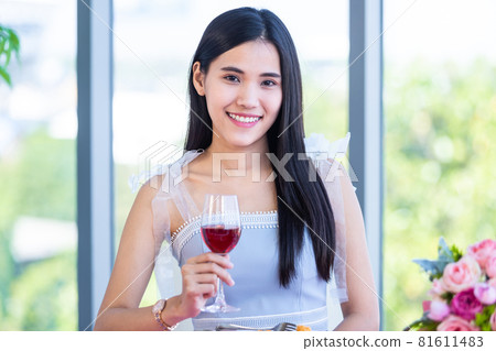 Valentine's day concept, Asian young girl sitting at a table food with wine glasses and bouquet of red and pink roses wine and waiting for her man at in the restaurant background Valentine's day concept, Asian young girl sitting at a table food with wine glasses and bouquet of red and pink roses wine and waiting for her man at in the restaurant background 81611483