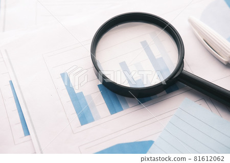 financial data and magnifying glass on blue . 81612062