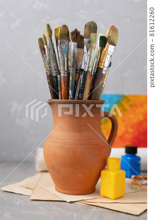 Paint brush in clay jug and art painter tool on table background texture. Paintbrush for painting 81612260