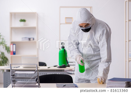 Young male contractor disinfecting office during pandemic 81613360