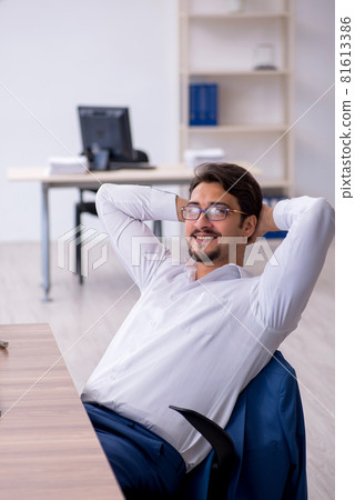 Young male employee and too much work in the office 81613386