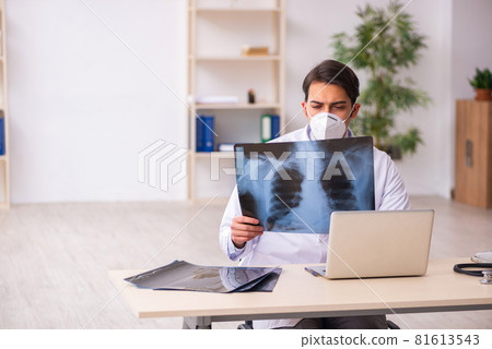 Young male doctor radiologist working in the clinic during pande Young male doctor radiologist working in the clinic during pande 81613543