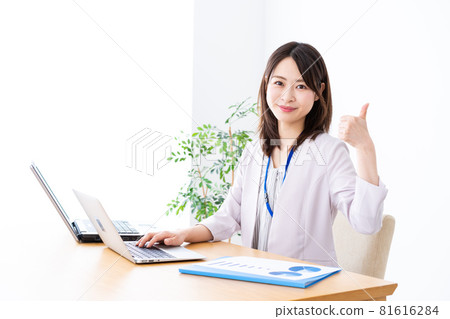 Young business woman giving a good sign in the office 81616284