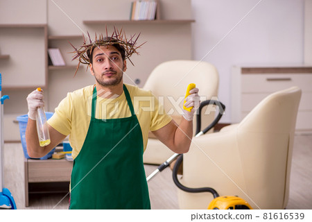 Young male contractor wearing prickly wreath on head cleaning th Young male contractor wearing prickly wreath on head cleaning th 81616539