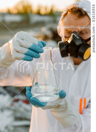 Close-up scientist examining sampling of toxic chemicals on polluted ground Close-up scientist examining sampling of toxic chemicals on polluted ground 81616958