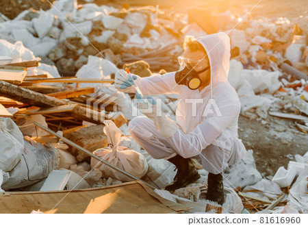 Researcher looking at plastic landfill analyzing environmental pollution level 81616960