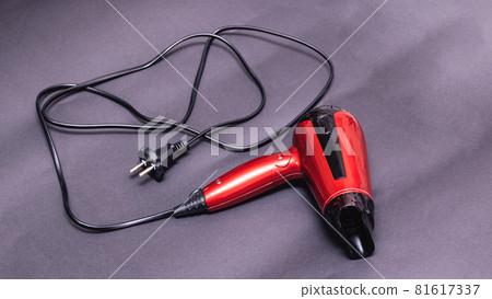 Red hair dryer on a purple background 81617337