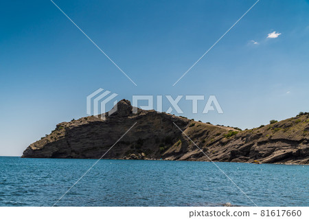 The Republic of Crimea. July 15, 2021. A picturesque view in sunny weather of Cape Kapchik, a silhouette resembling a dolphin, from the observation deck on the Golitsyn trail. The Republic of Crimea. July 15, 2021. A picturesque view in sunny weather of Cape Kapchik, a silhouette resembling a dolphin, from the observation deck on the Golitsyn trail. 81617660